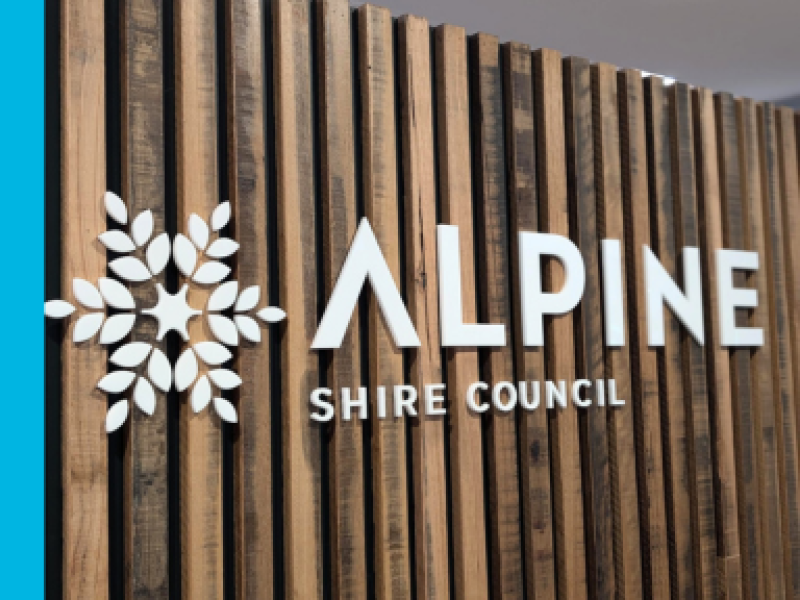 Alpine Shire Council's logo on a timber wall