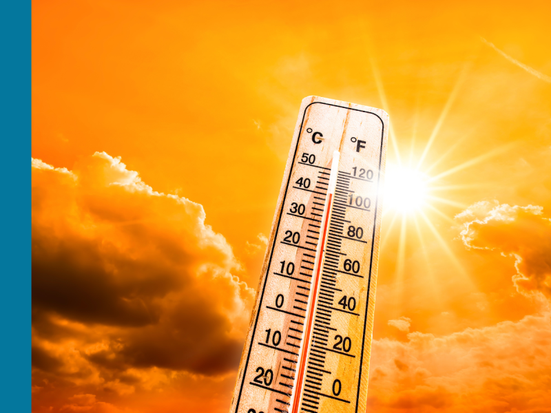 A thermometer showing a high temperature with an orange sky and bright sun in the background